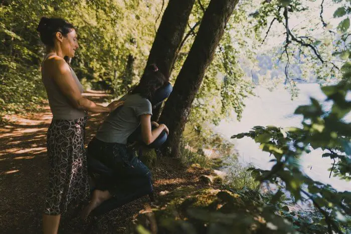 Tout près du lac, Sarah est en train de masser une cliente sur chaise ergonomique.